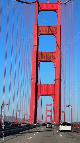 Driving across Golden Gate Bridge in San Francisco with red towers and light traffic 