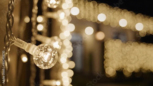 Warm Golden String Lights Illuminate a House Exterior at Night Creating a Festive and Inviting Ambiance with Soft Bokeh Effects in the Background
