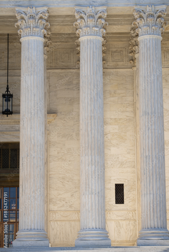 Naklejka premium Monumental columns emphasizing historic architecture. Marble pillars supporting grand architecture. Government building with timeless columns. Classical facade with massive stone columns.