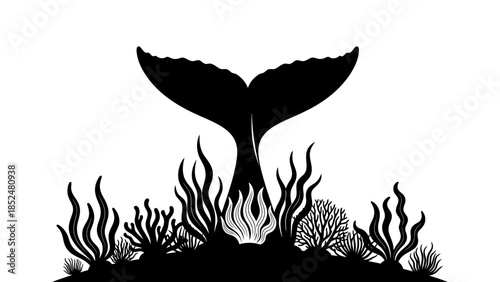 Silhouette of a whale tail diving into the ocean with coral reef below.