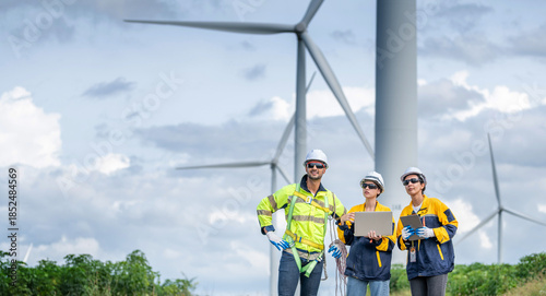 Team of Engineers Planning Project for Renewable Energy Professional Team Inspecting Wind Turbines for Clean Energy Generation Collaboration : Engineers with Blueprint at Wind Farm.