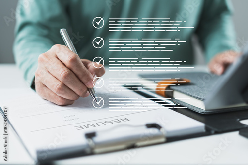 Pen marking printed checklist with resume layout