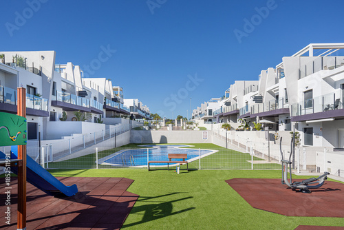 Obraz na plátně Modern apartment complex with shared playground, gym area, and swimming pool