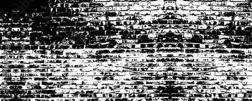 a high contrast black and white image showing a distressed brick wall with a weathered appearance.