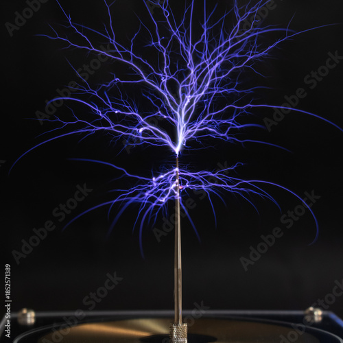 A bright electrostatic discharge from a Tesla coil with blue branching lightning bolts