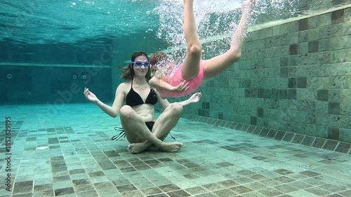 Underwater yoga practice in a swimming pool during summer
