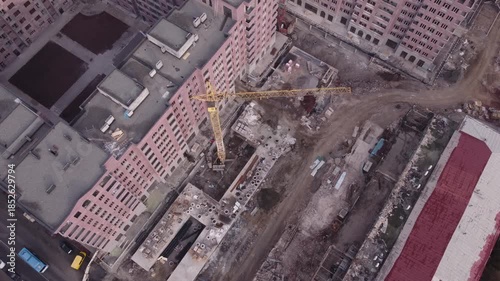 Top down aerial view of a crane operating at a construction site for new housing complexes