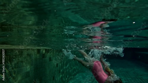 Swimming practice in a residential pool with child and splashes of water