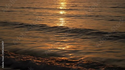 Golden Sunset Reflections on Rippling Water with Textured Waves and Gentle Movement