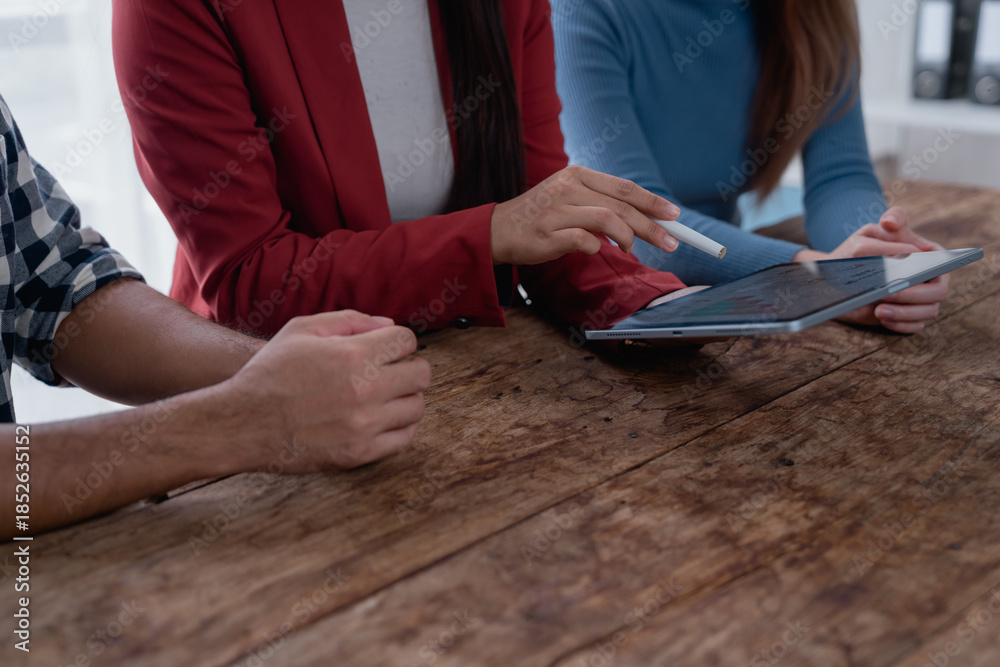 Obraz premium Business team collaborating on data analysis using digital tablet