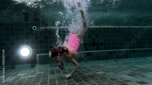 Children swimming underwater in a pool during afternoon play time