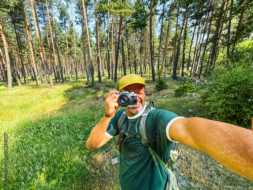 фотографія Man taking selfie with camera while hiking in forest