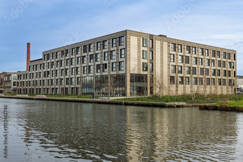 Modern temporary container housing complex in Utrecht located by the water, providing sustainable and modular living spaces for residents.