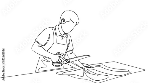 Person cutting fabric with large scissors on table