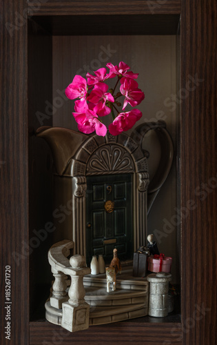 Still life with blooming geraniums in a ceramic milk jug.