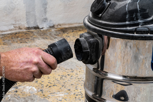 Quadro su tela Hand attaching vacuum hose to industrial vacuum cleaner