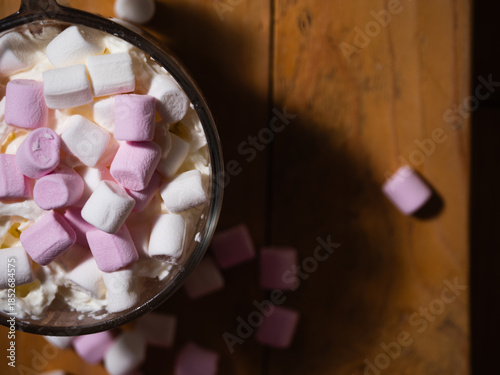 Sprinkling toppings on hot chocolate with marshmallows