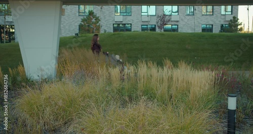 Mother pushing stroller in modern residential park