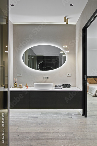 Luxury bathroom vanity unit on wooden floor in open-plan bedroom layout
