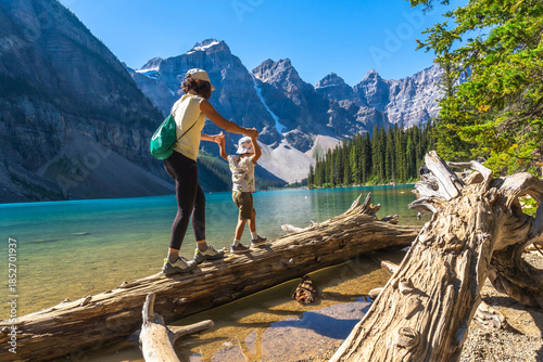 Fotografie Mother and child balancing on log at moraine lake, banff national park