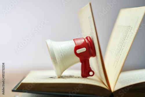 Small megaphone on top of open book.