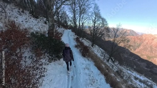 Monte Lema, Varese, Italy: girl walks halfway up the mountain in the shadow