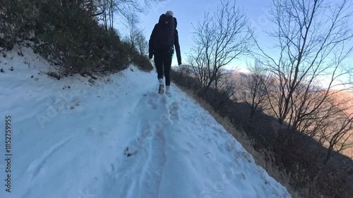 Monte Lema, Varese, Italy: Hiking day in the mountains on the snow, girl walking halfway up the hill
