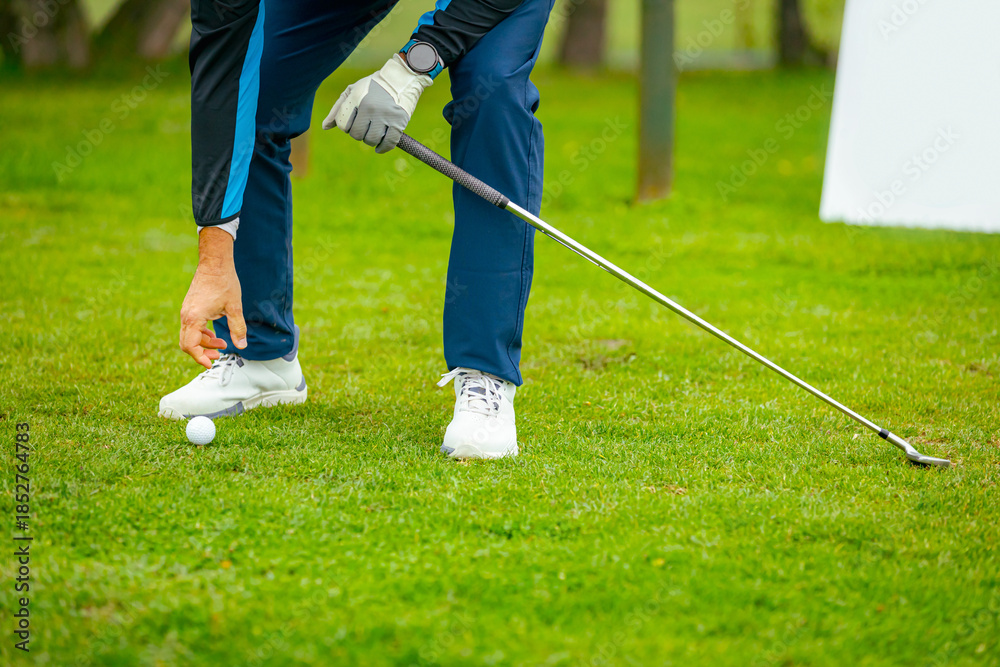 Fototapeta premium Golfer's hand placing ball on a golf tee