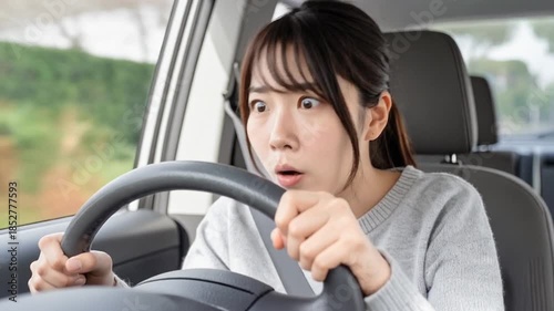 恐る恐る自動車を運転するペーパードライバーの若い女性