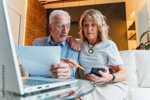 Photos Senior couple calculating household finances and budgeting expenses at home, man