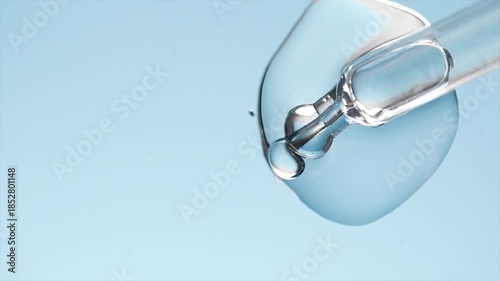 Cosmetic dropper, glass pipette with serum, beauty cosmetics dripping, on blue background. Science. Serum, peptides, beauty and health care products. liquid enzymes close up. Top view. Skin care