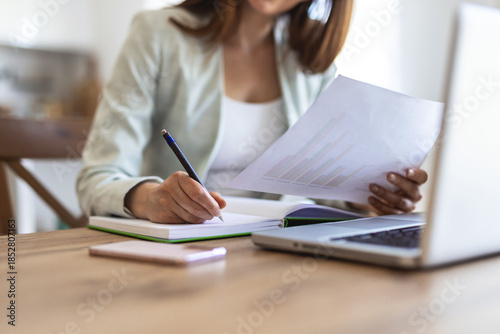 Foto Laptop and writing with business woman in office for real estate broker, property listing and planning