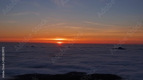 sunset over clouds/clouds under the mountains