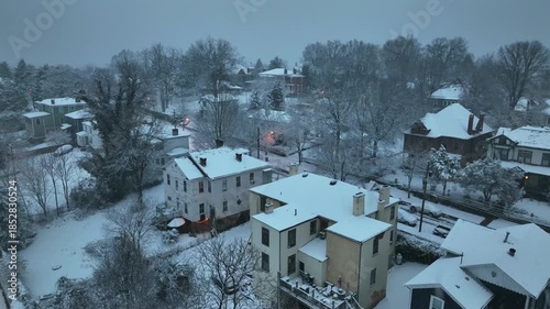 Wallpaper Mural Snowfall In quiet suburb neighborhood of american town. Cloudy cold winter day with snow-covered roofs of single family houses. Lighting lantern along street at dusk. Aerial view. Torontodigital.ca