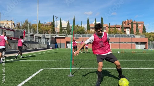 Young soccer player dribbling ball during training session