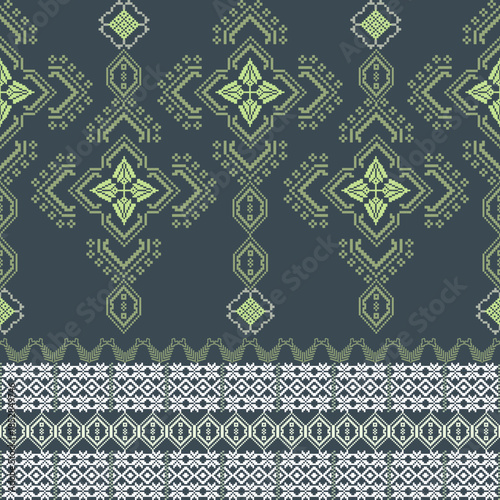 Yellow and white cross-stitch ethnic boho seamless pattern on a dark green background. Tribal pattern. Folk motif. Textile rapport. Pixel vintage pattern. Design for fabric edge and wallpaper.