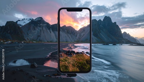 Phone displaying a scenic landscape with mountains and a colorful sky.