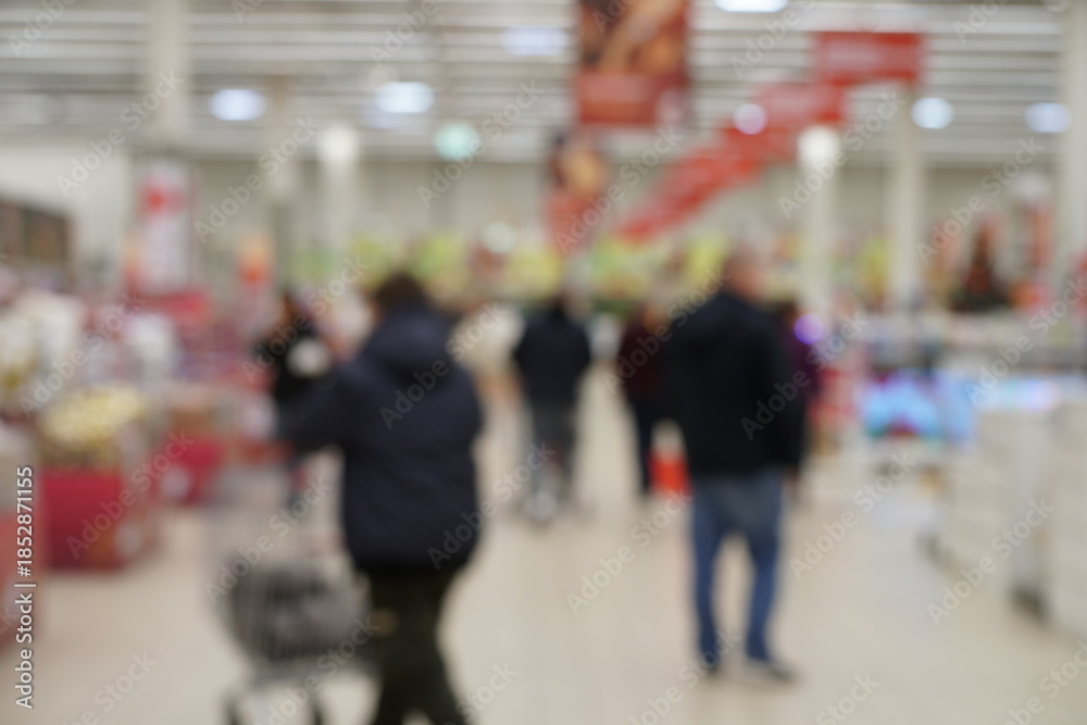 Naklejka premium Blurred background. People buy groceries at the supermarket.