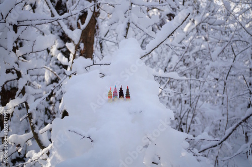Colorful toy gnomes made of plasticine in the forest against a background of snow. Fabulous scenery.