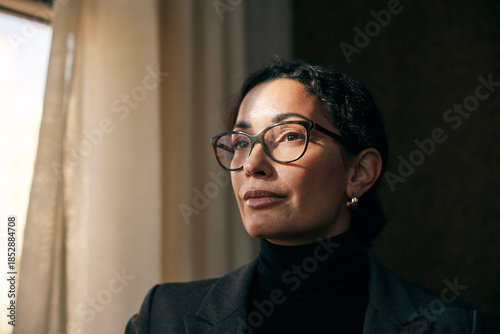 Contemplative female financial advisor wearing eyeglasses looking away