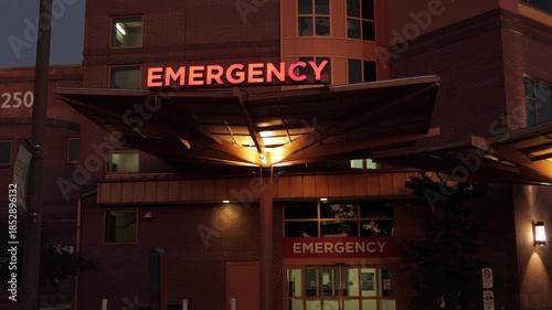 Hospital Emergency Room Entrance with Red Signage. Emergency Sign at Hospital in USA. Emergency Room and Medical Care Building. Hospital, Medical Center, Emergency Room. Evening Night Times.