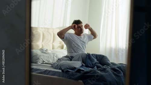 Canvas Print Caucasian man lying bed waking up stretching good morning in bedroom at home sle
