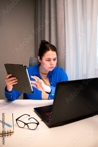 Online business owner managing her e-commerce store from home. Entrepreneur analyzes data on computer screen in home setting. Modern reality of running successful digital business remotely