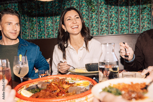Happy woman having dinner with friends at fine dining restaurant