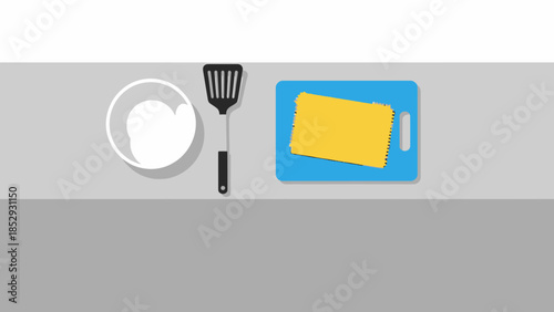 Top down view of cheese on a cutting board with a bowl and spatula.