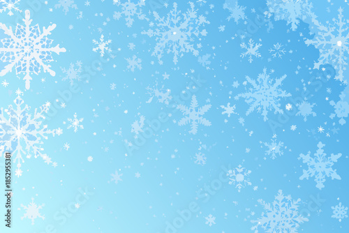 Delicate white snowflakes falling against a bright clear blue winter sky