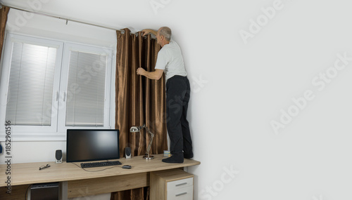 Senior citizen fixing curtain rod. Pensioner standing on the desk. Home accident
