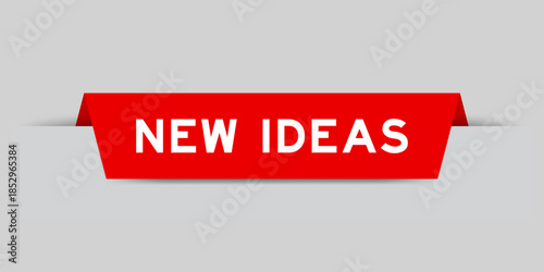 Red color inserted label with word new ideas on gray background