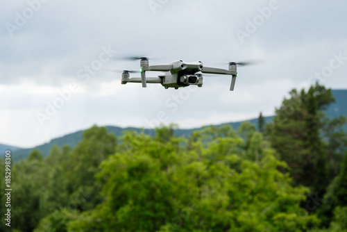 An unmanned aerial vehicle flies in the air low above the ground