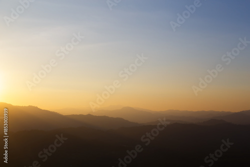 Sunset Over Mountains with Golden Sunlight and Haze